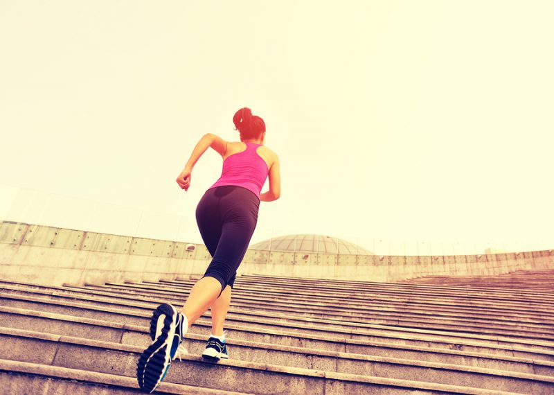 Runner athlete running on escalator stairs. woman fitness joggin
